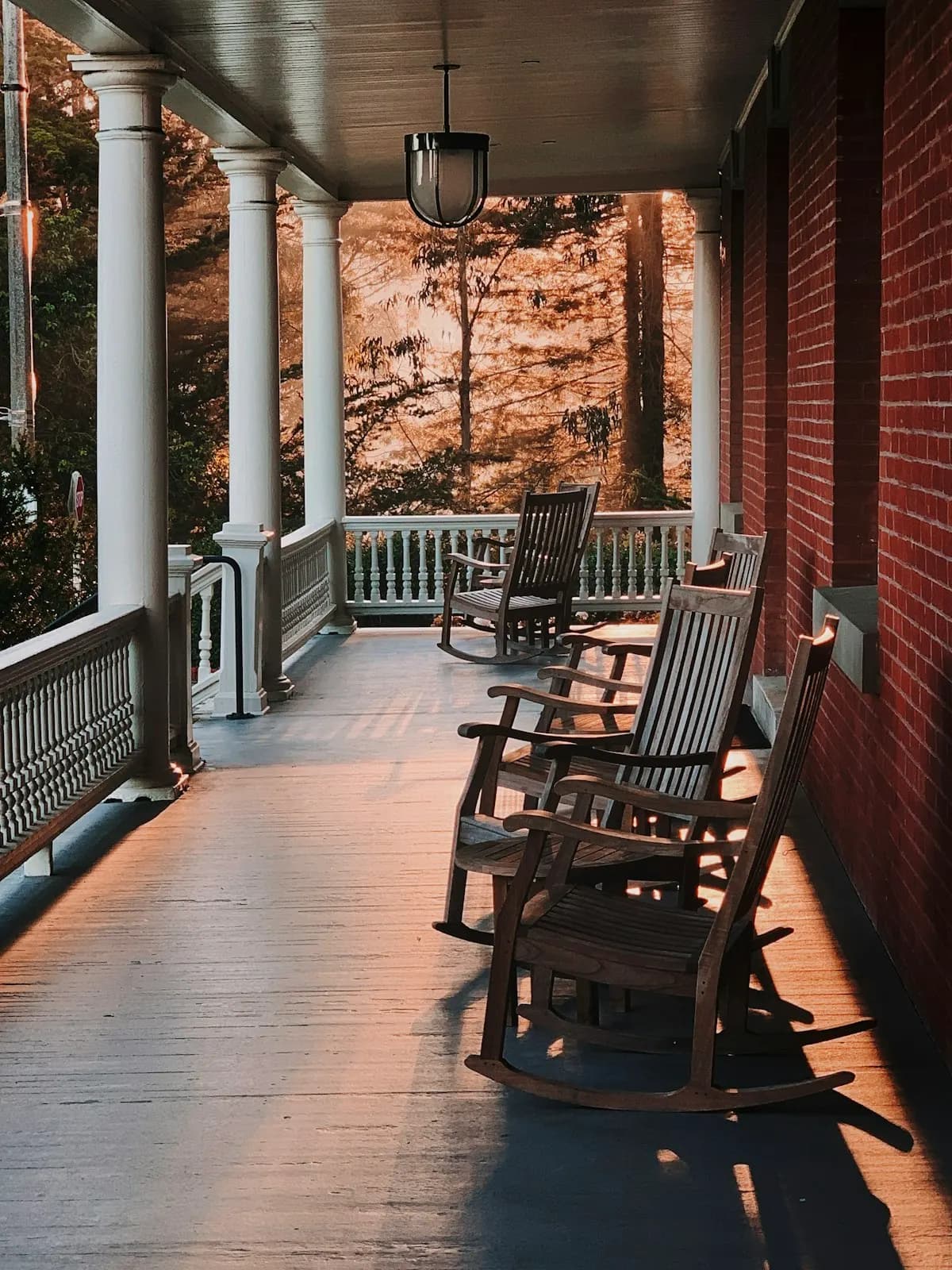 Long covered porch with a row of rocking chairs