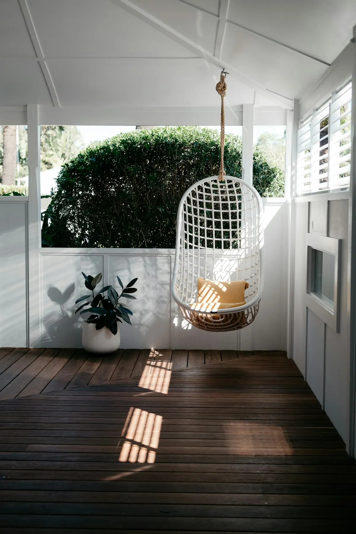 Hanging chair in a white screened porch