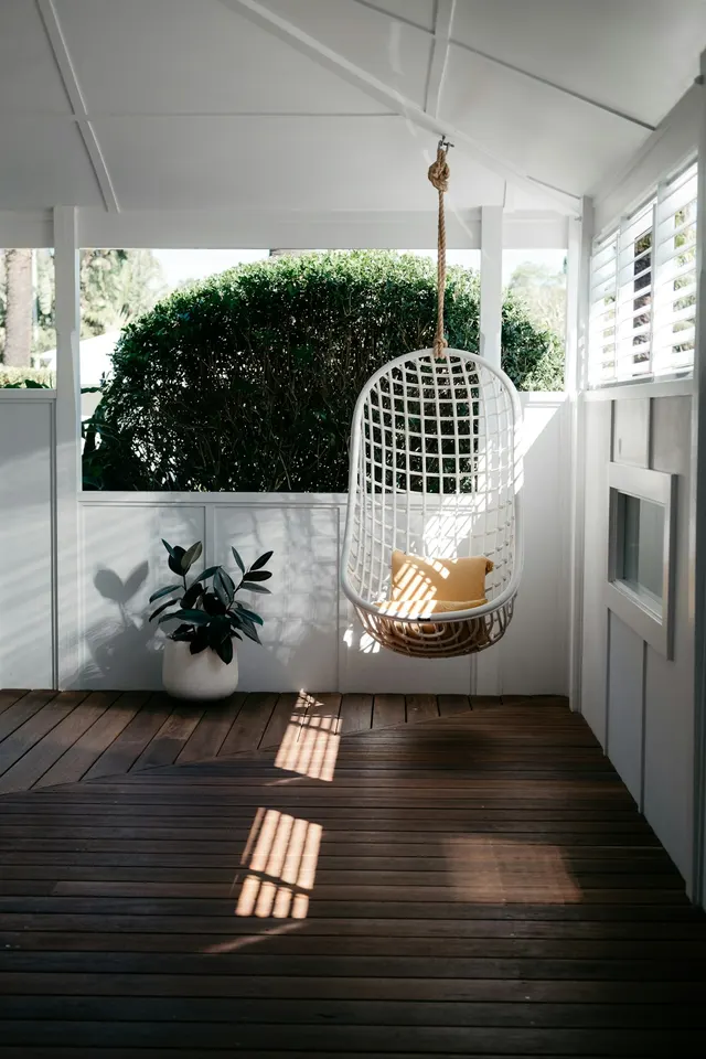 Hanging chair in a white screened porch