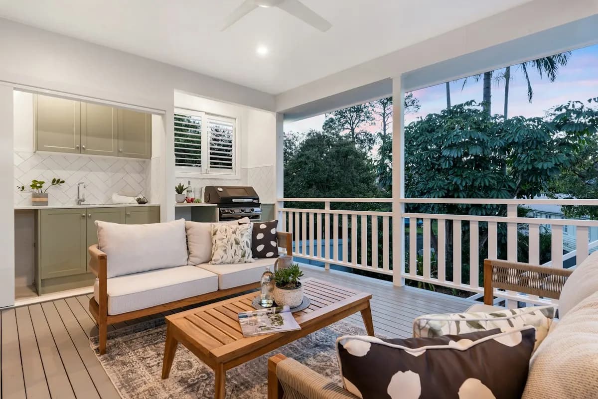 Covered porch with outdoor seating, kitchen cabinets and a grill