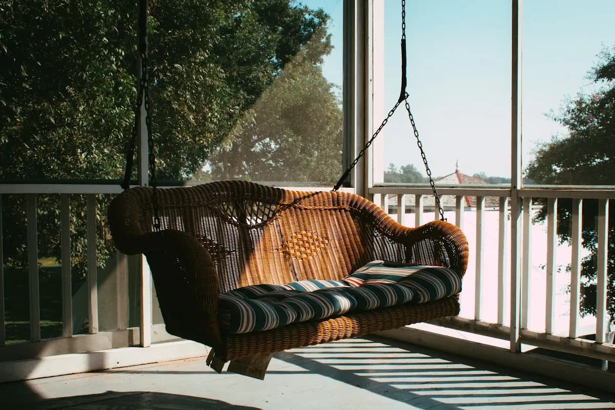 Hanging porch swing beside a white railing